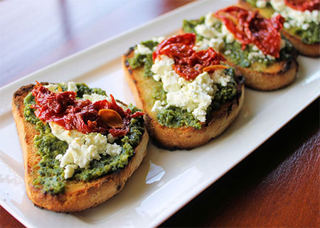 Bocaditos de hojaldre al pesto con queso de cabra y tomate seco.